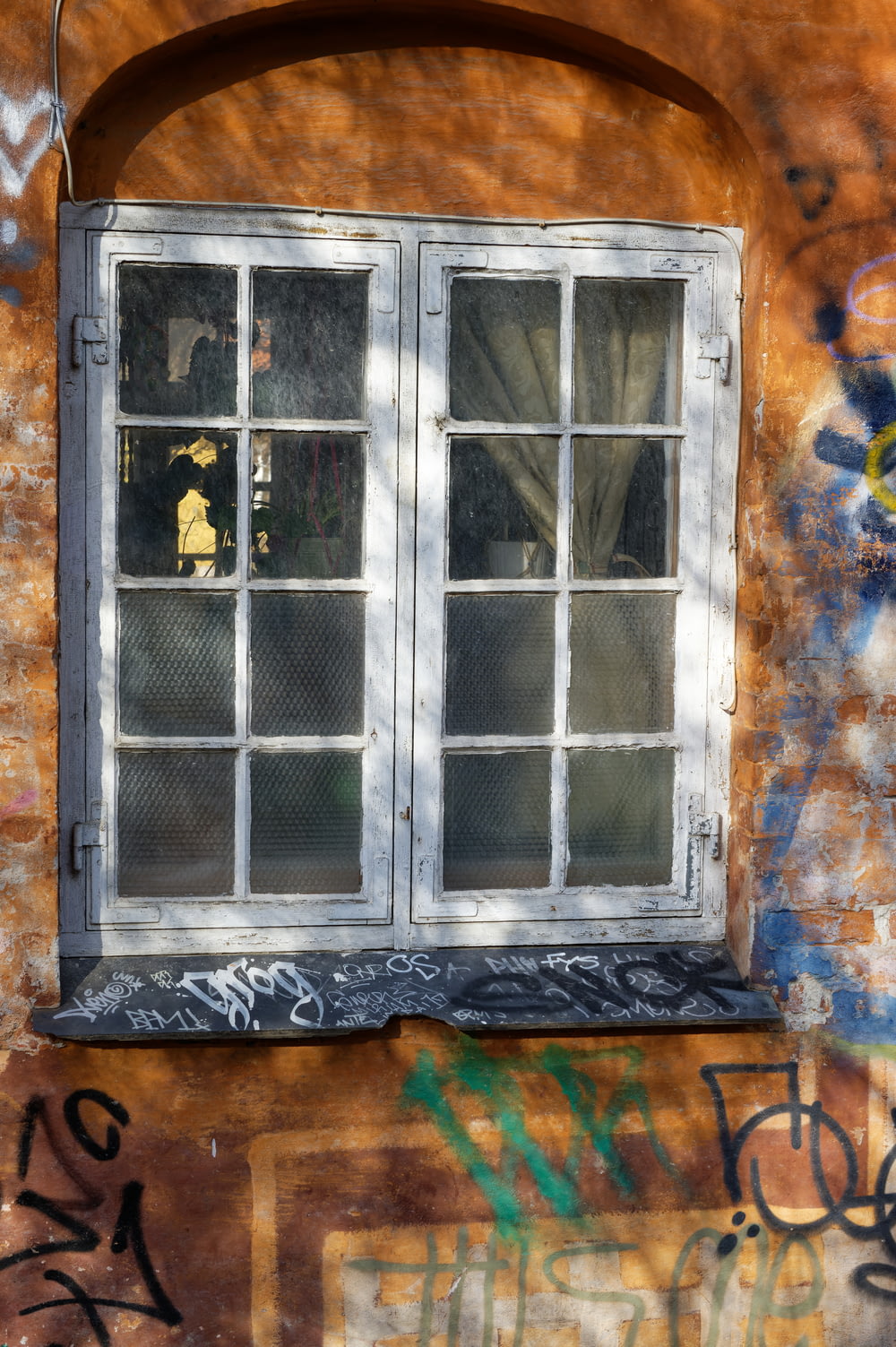 낙서가있는 벽돌 벽의 창