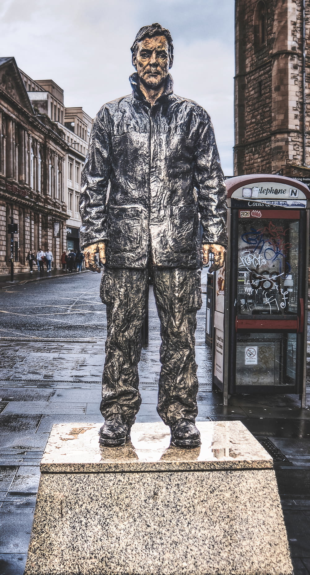 a statue of a man standing on a sidewalk