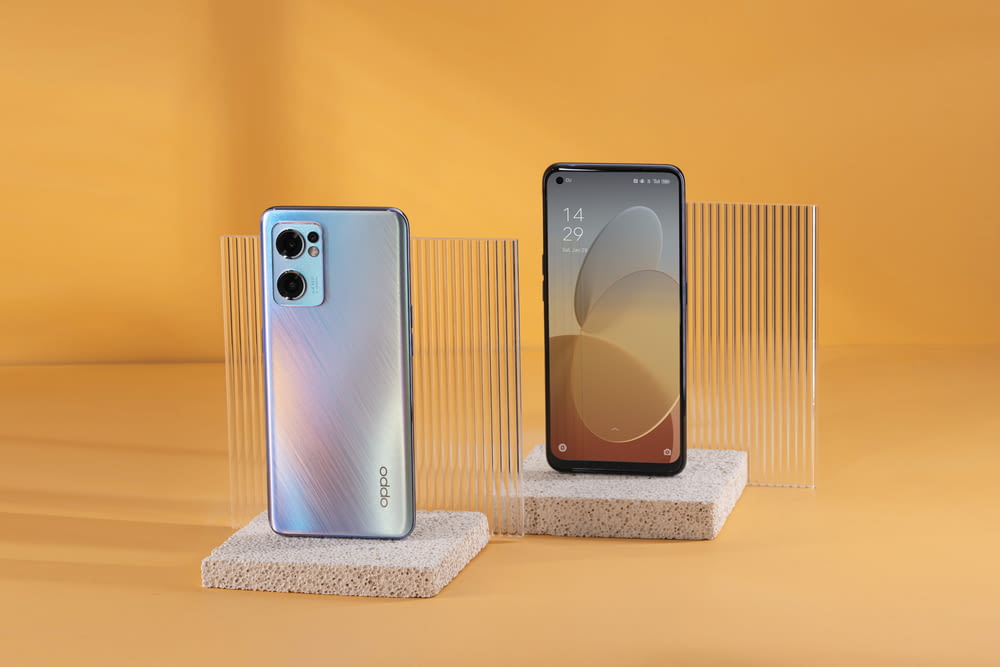two new cell phones are displayed on a stand