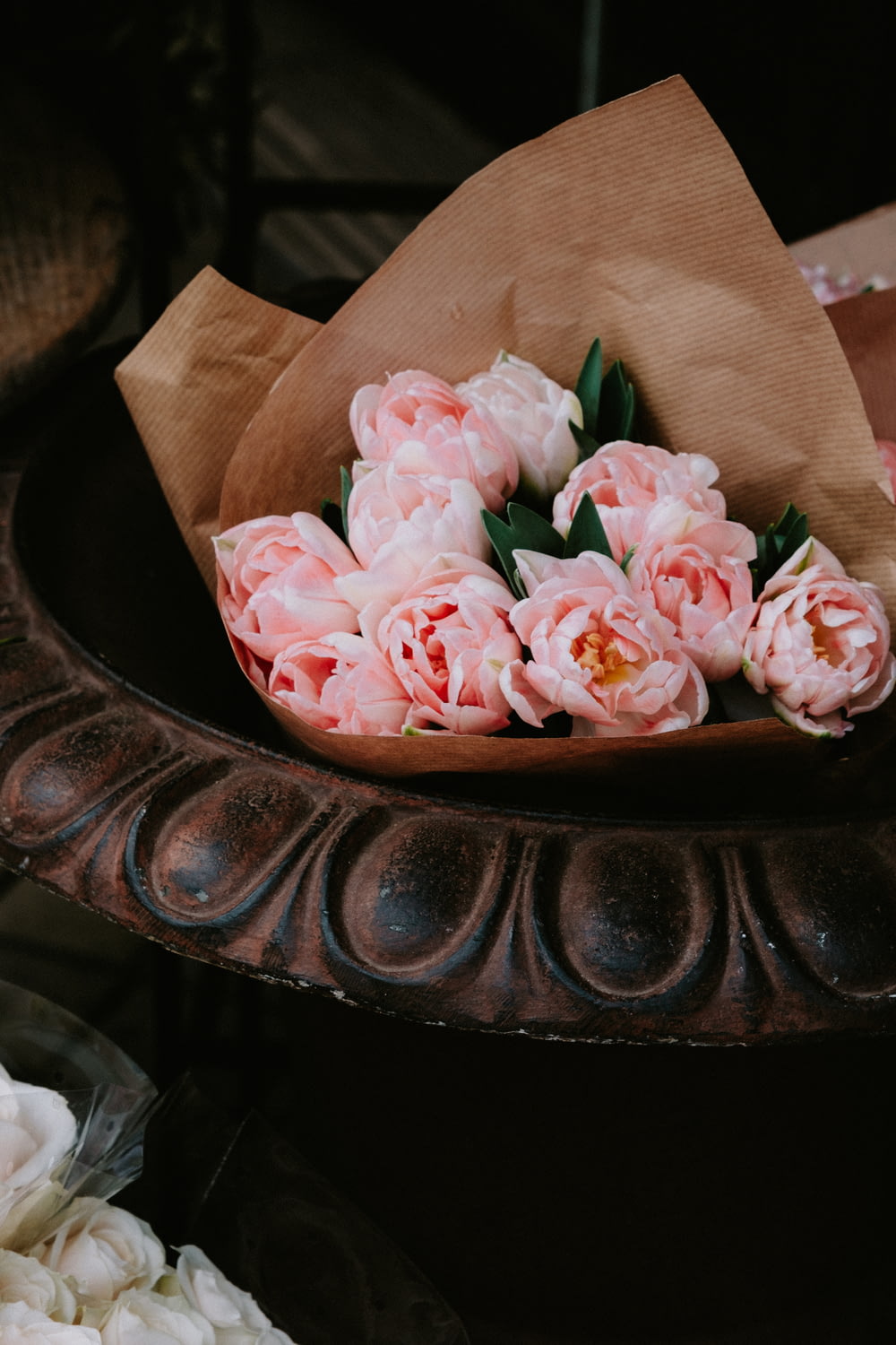a brown paper bag filled with pink flowers