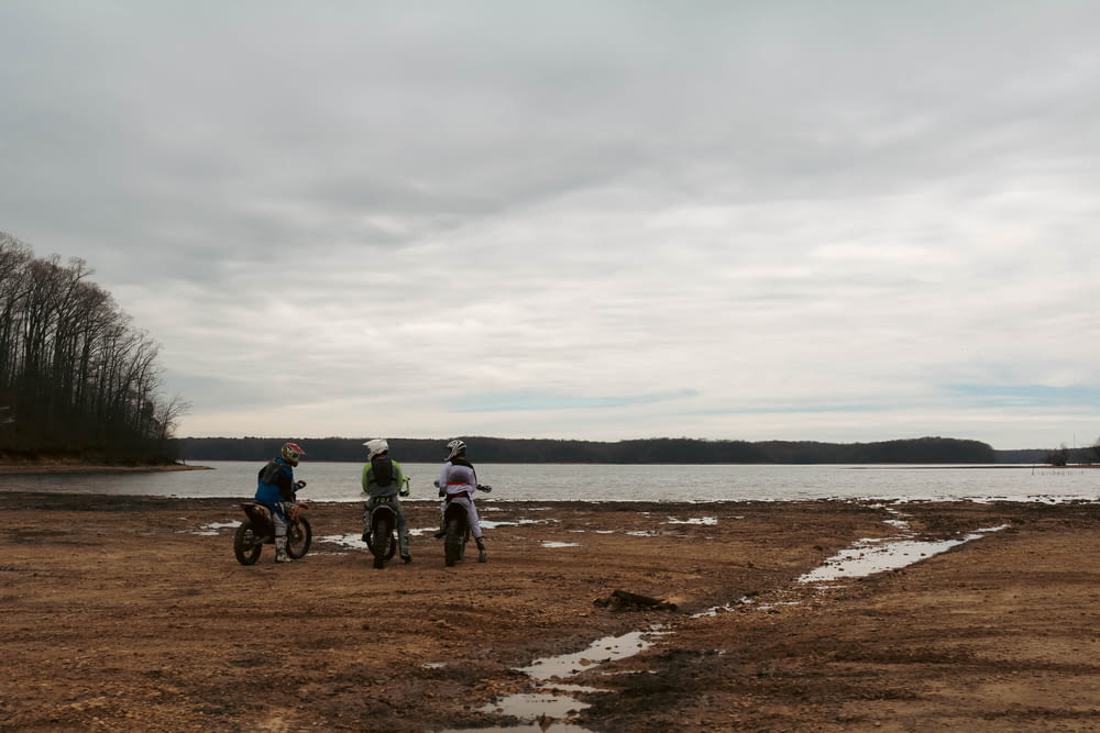 a couple of people on dirt bikes near a body of water