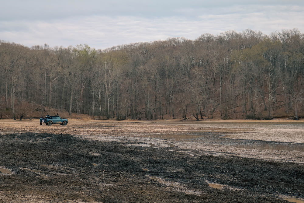 a truck is parked in the middle of a muddy field