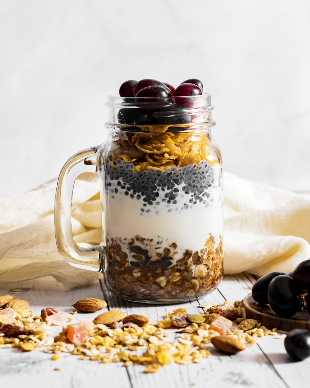 a glass jar filled with granola and fruit