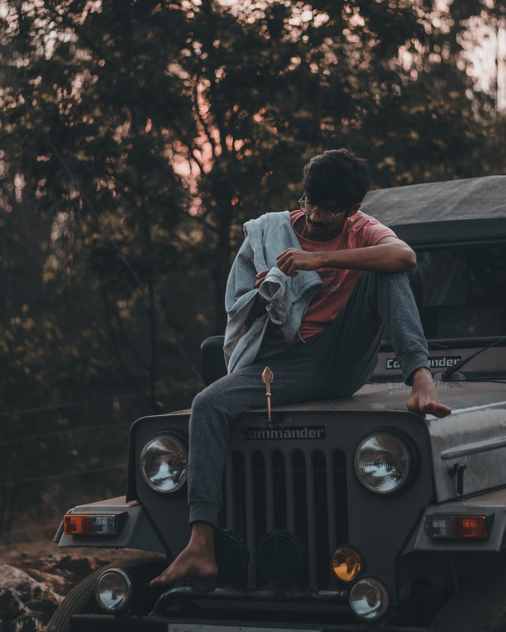 a man sitting on top of a jeep