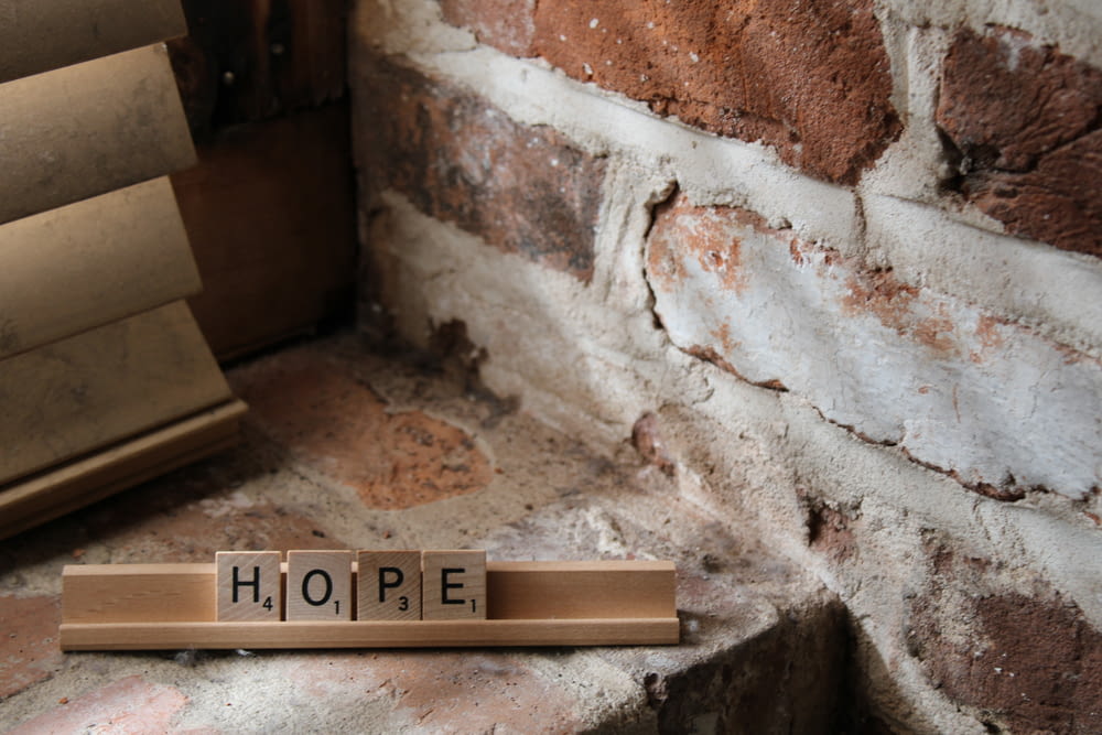 a scrabble type scrabble block with the word hope written on it
