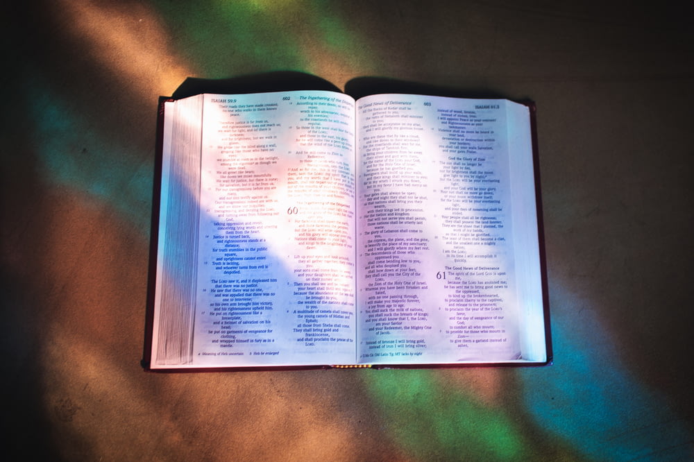 an open bible on a table in the sunlight