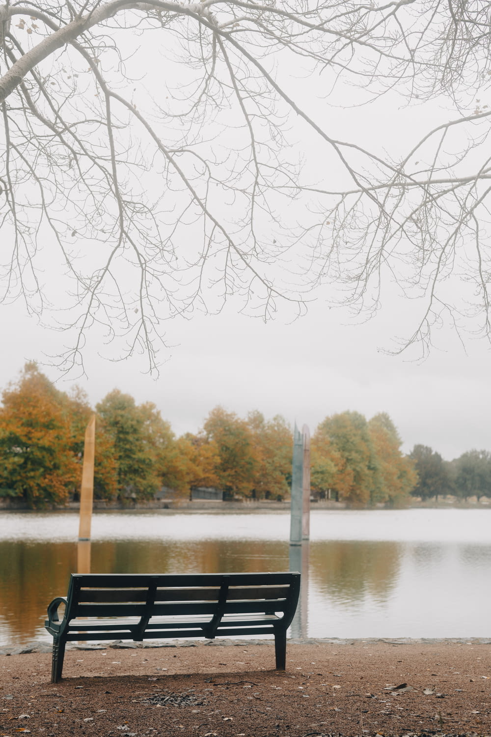 a park bench sitting in front of a body of water