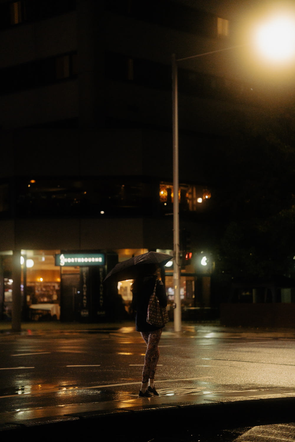 a person holding an umbrella on a rainy night