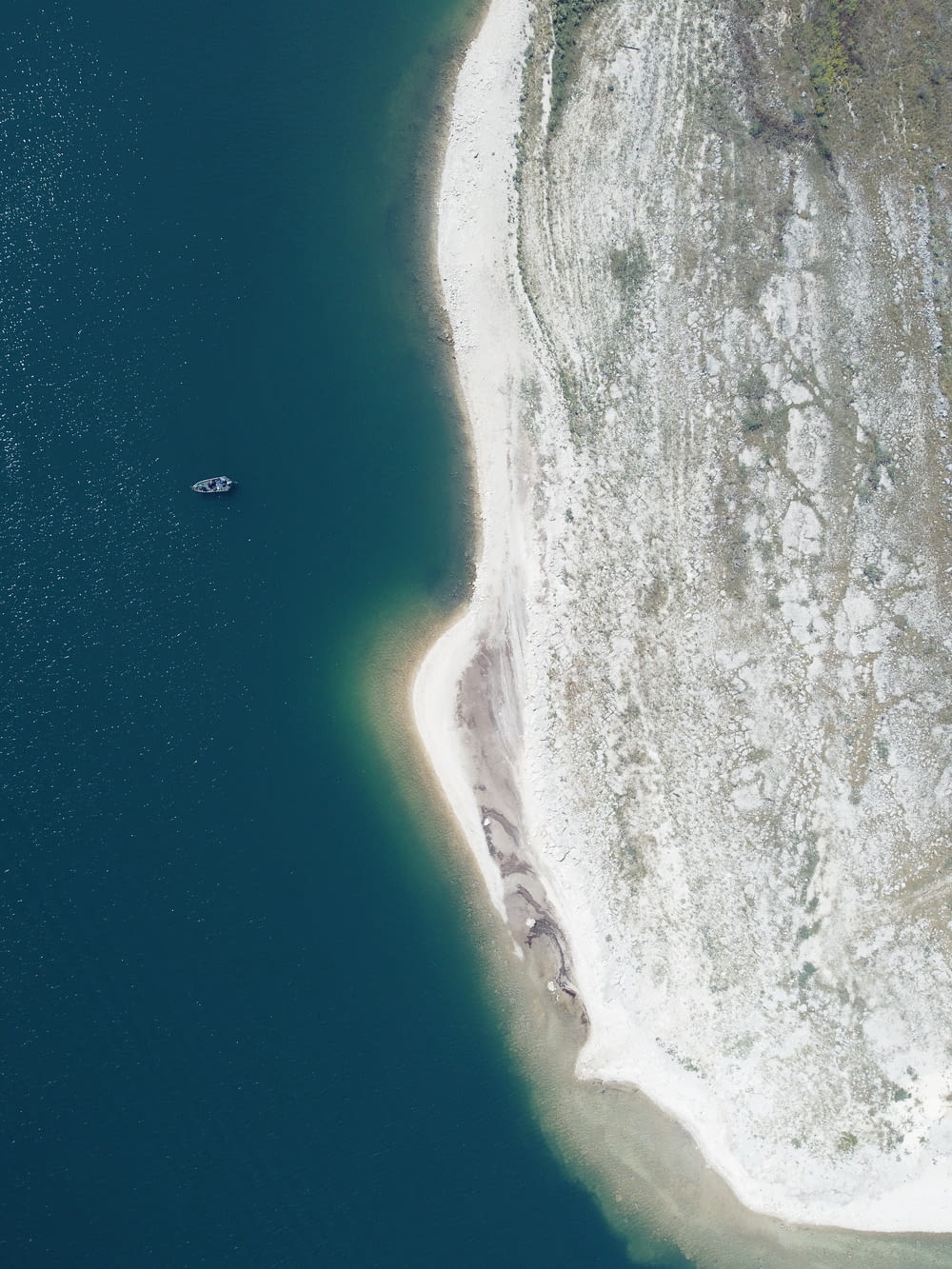 an aerial view of a boat in a body of water