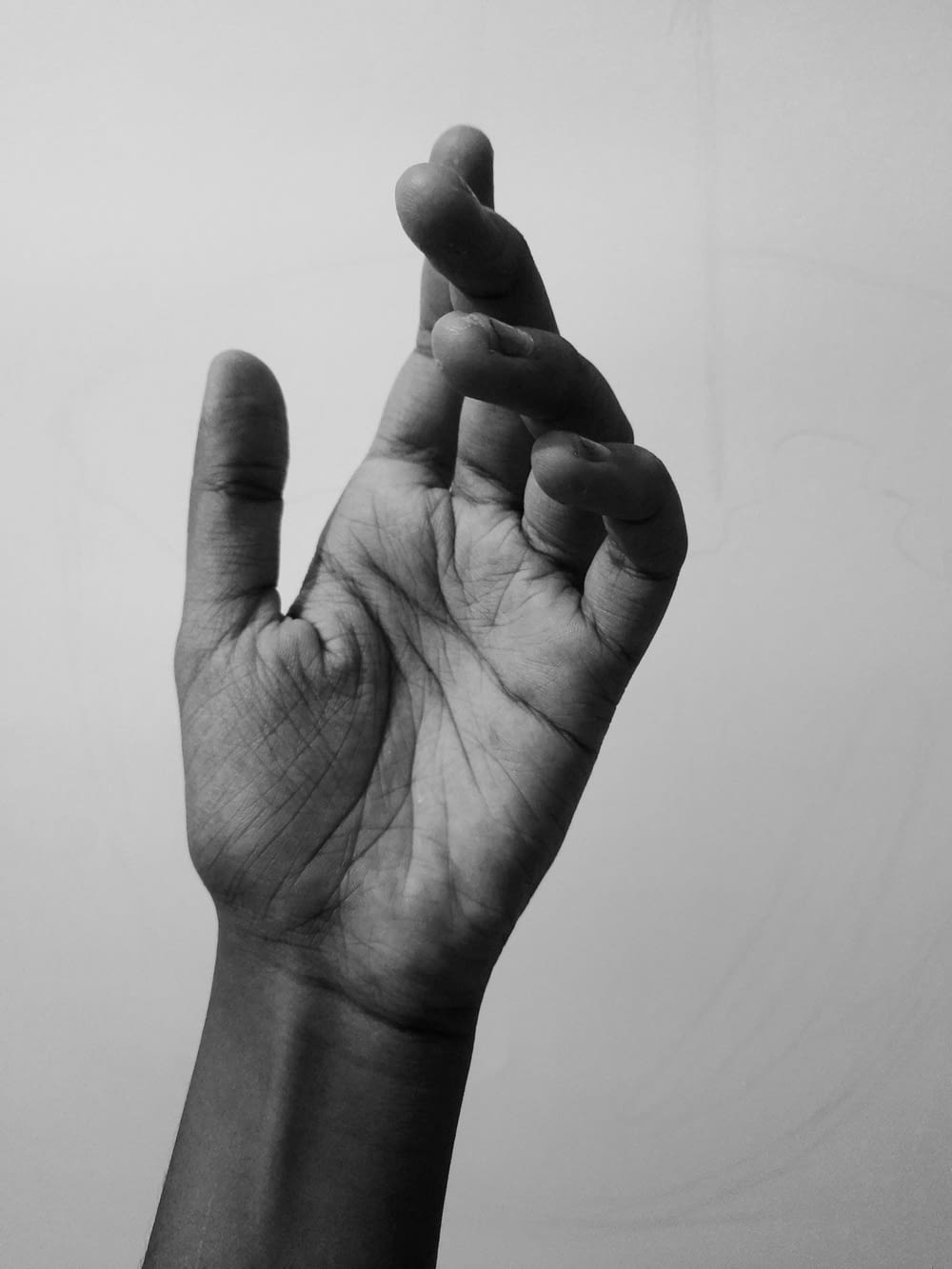 a black and white photo of a person's hand making the vulcan sign