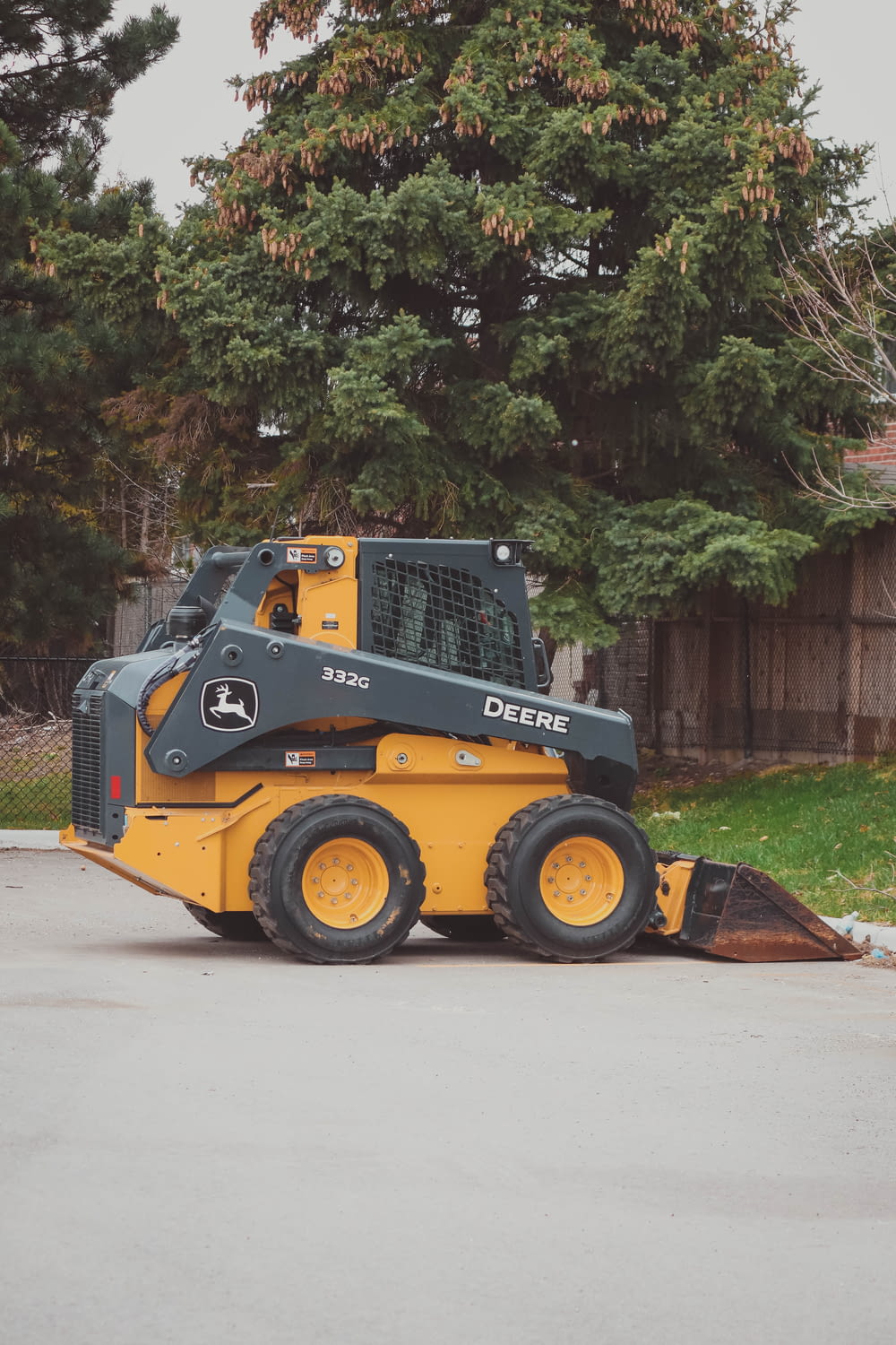 a yellow and black skid steer parked in a parking lot