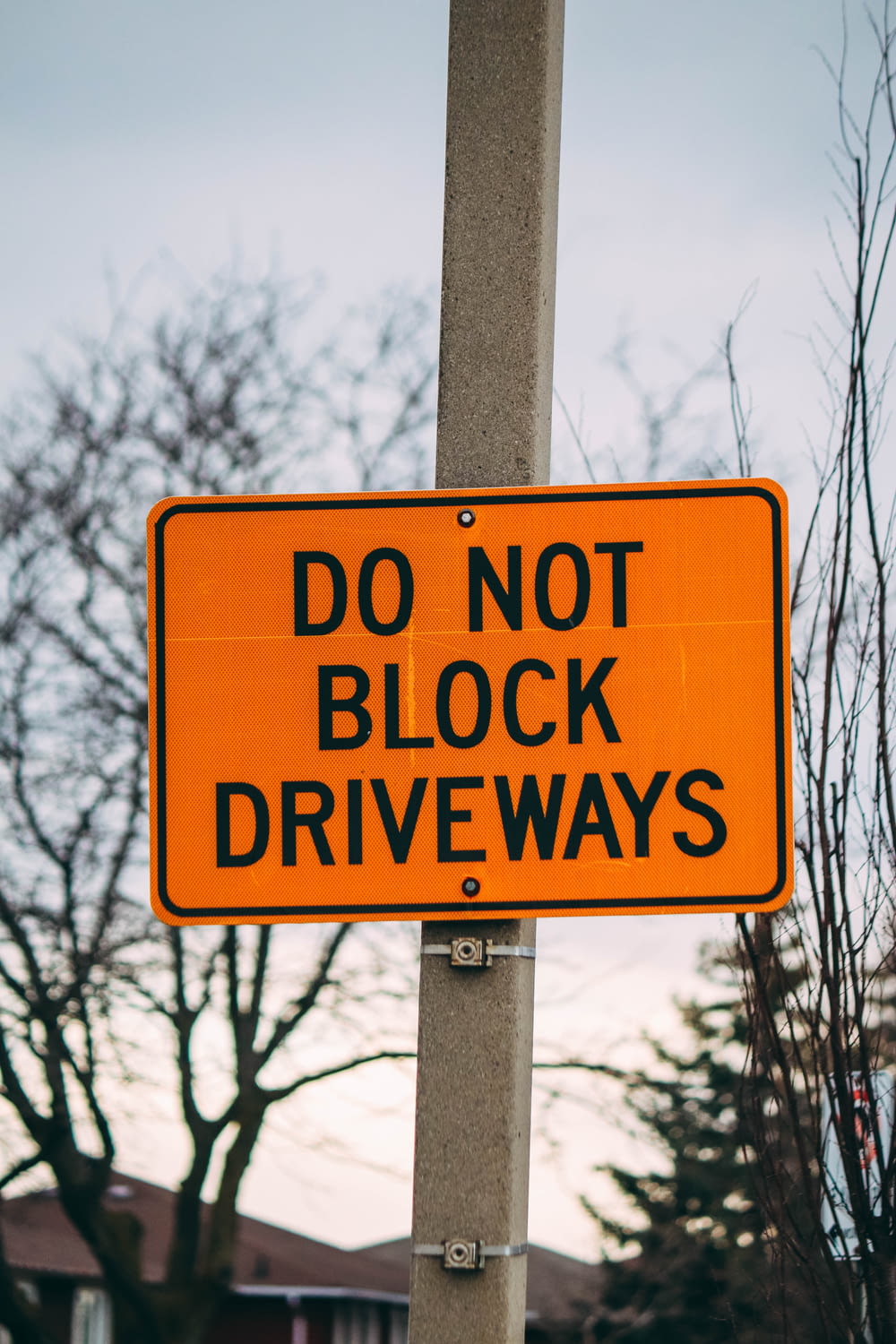 a do not block driveway sign on a pole