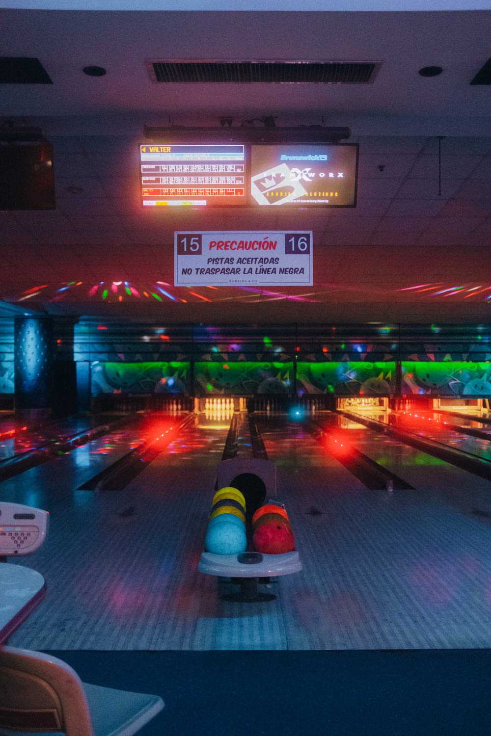 a bowling alley filled with bowling balls and neon lights