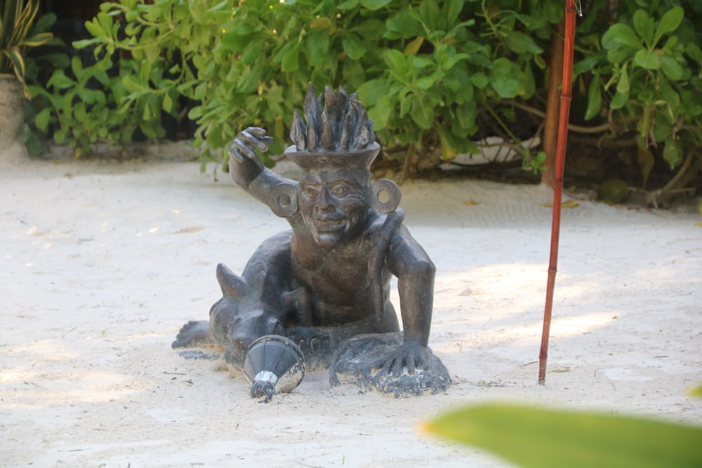a statue of a troll on a sandy beach