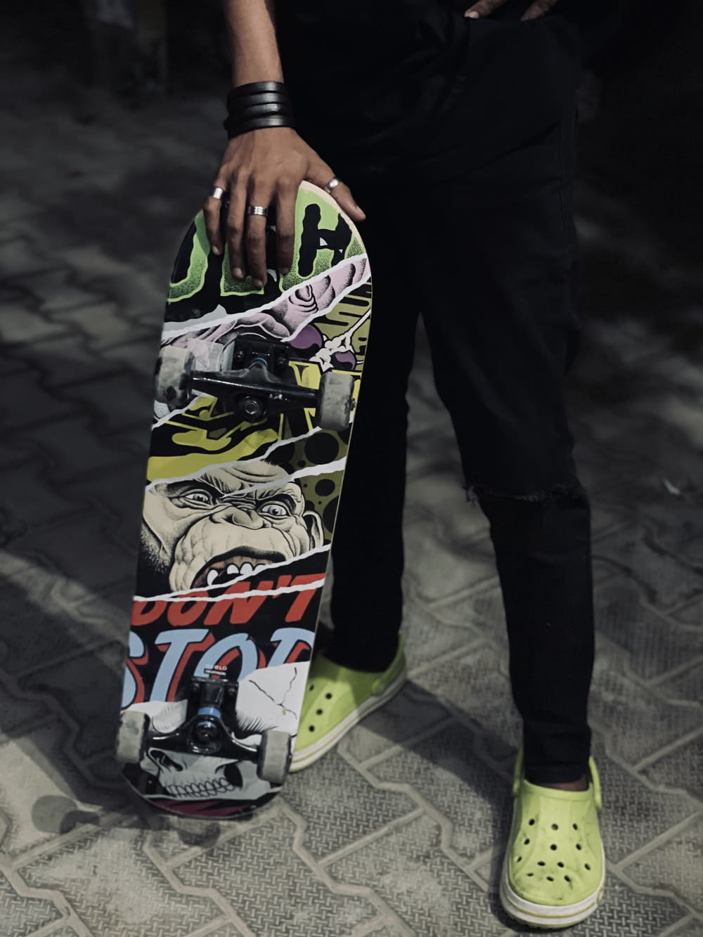 a person holding a skateboard on a sidewalk