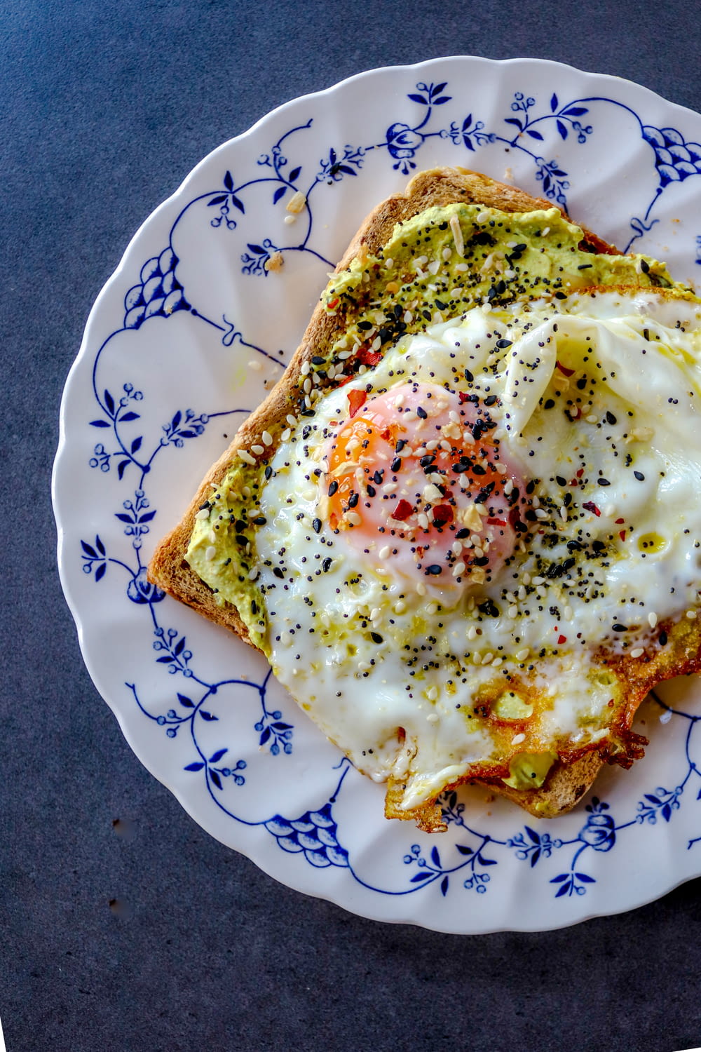 a plate topped with a piece of toast covered in an egg