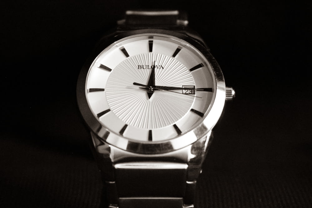 a silver watch with a black band
