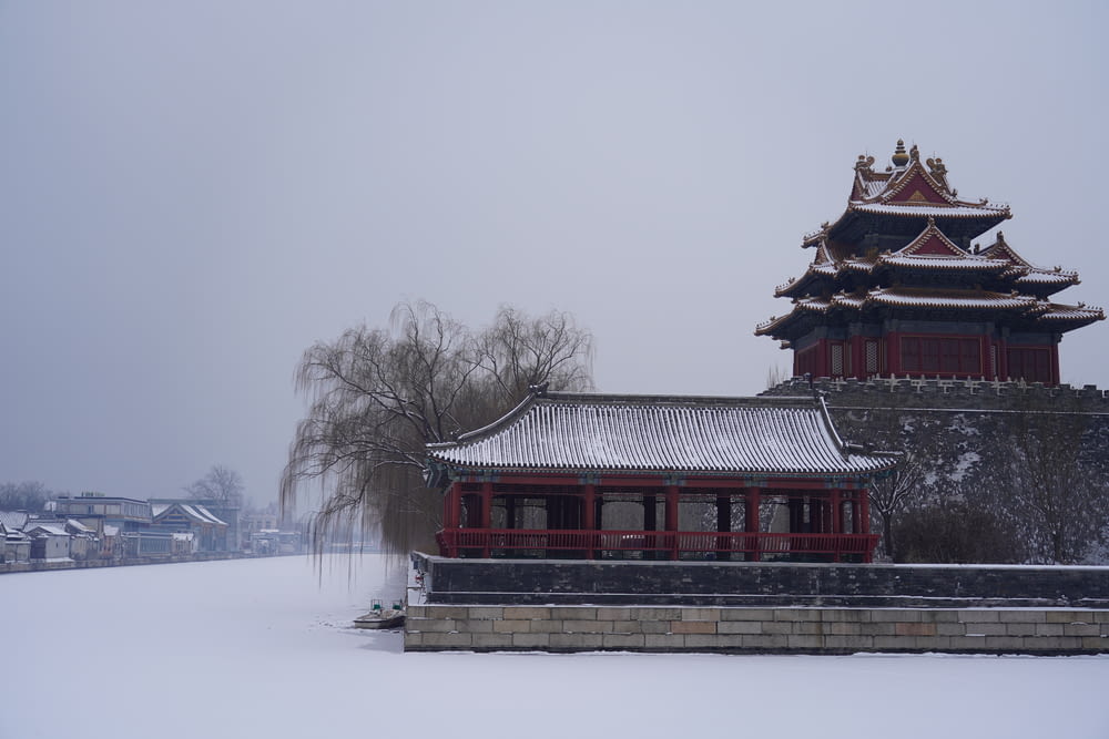 a building with a red roof and a snow covered ground