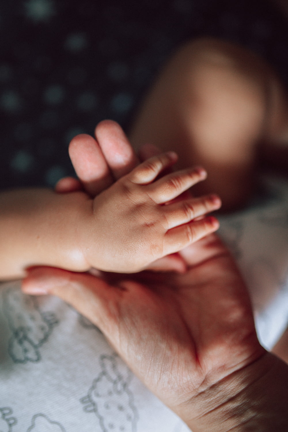 a baby's hand holding a baby's foot