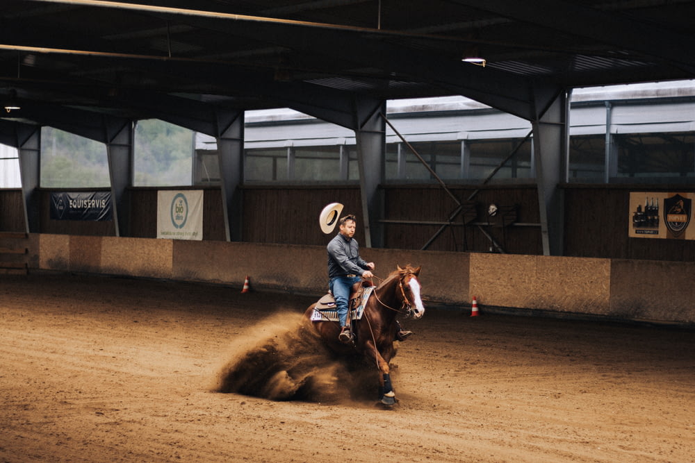 a man riding a horse on a dirt track