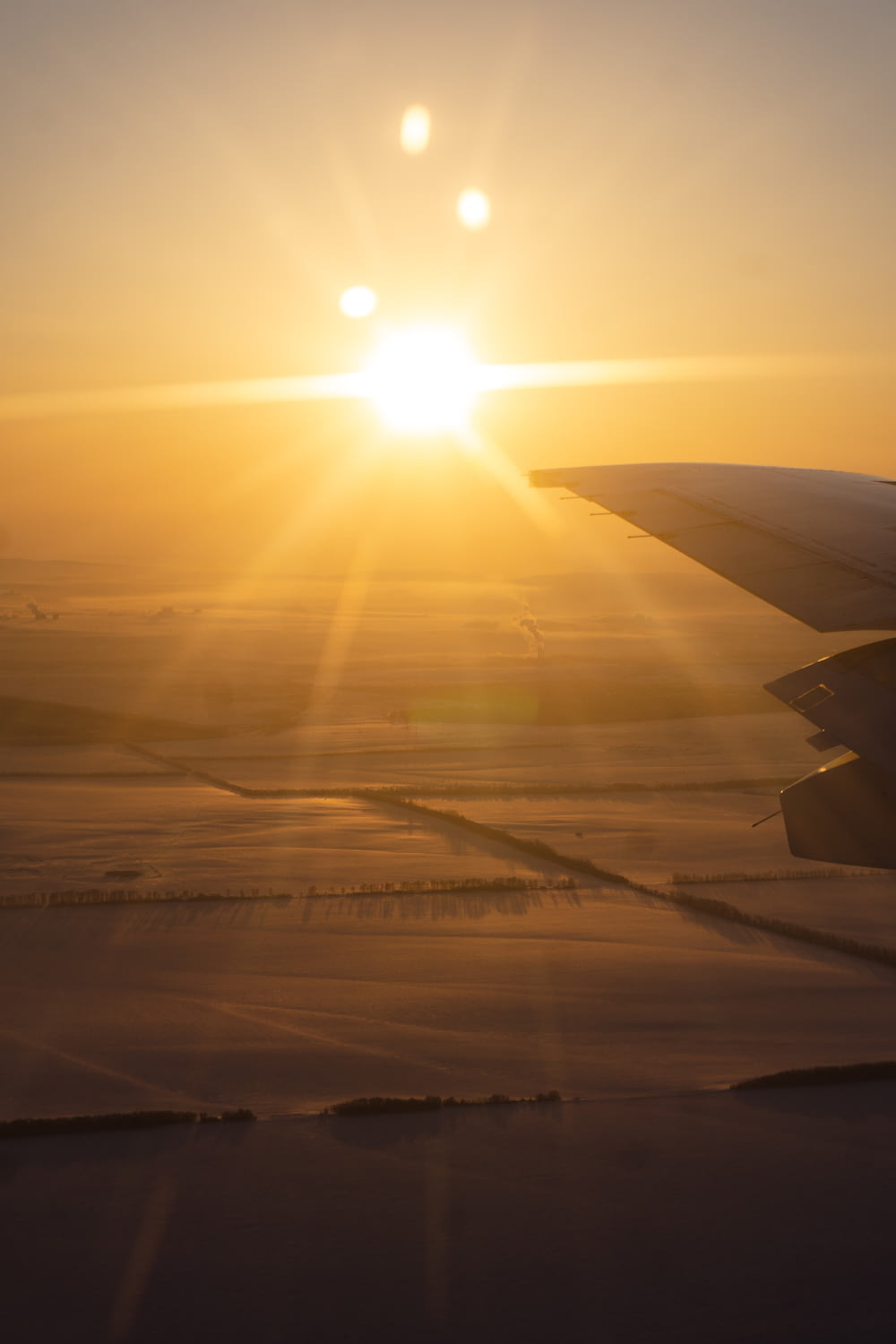 the sun setting over a plane wing