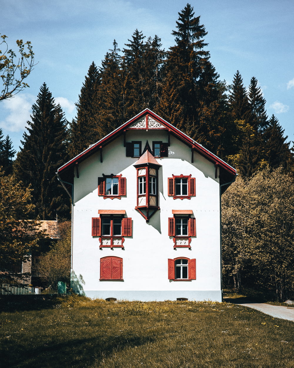 Une maison blanche avec des garnitures rouges