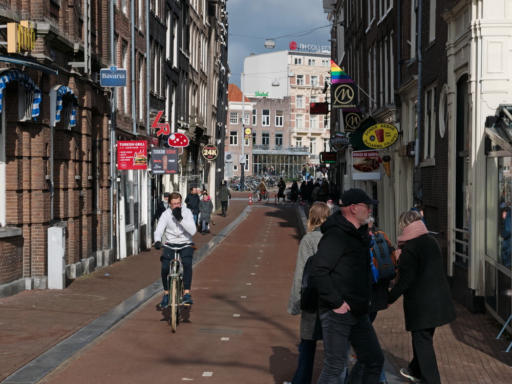 una persona in sella a una bicicletta lungo una strada trafficata