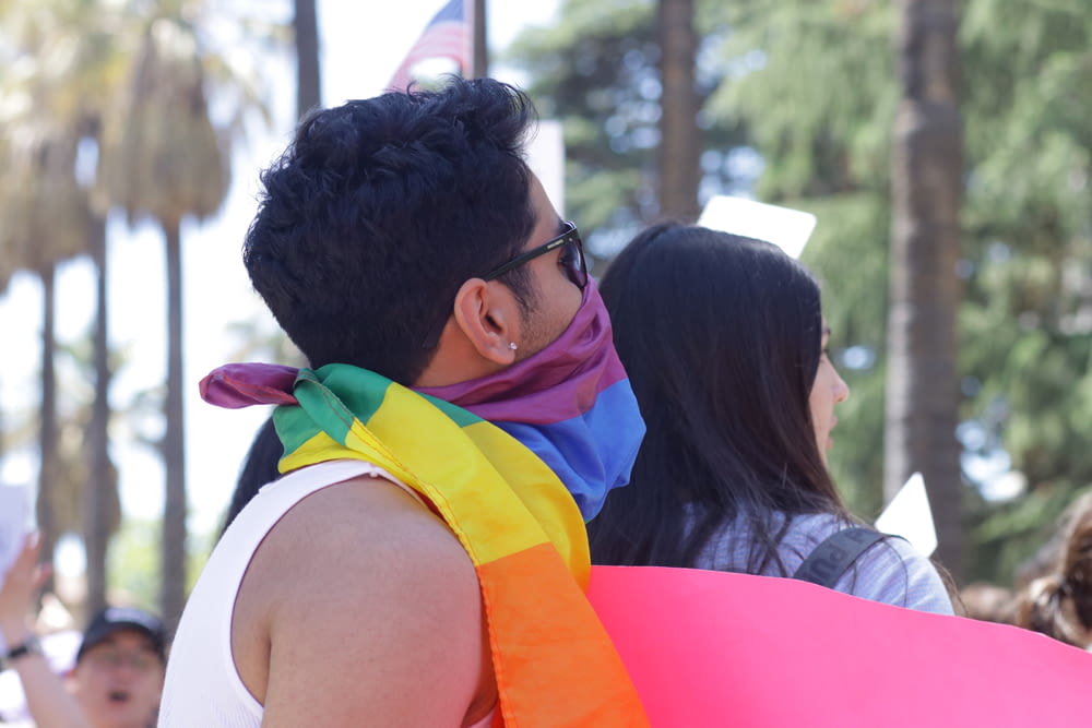 a man with a rainbow scarf around his neck