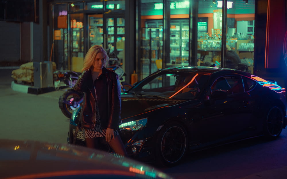 Eine Frau steht neben einem Auto auf einem Parkplatz