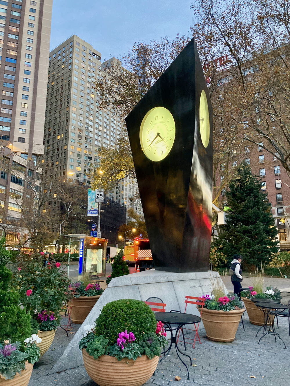 a sculpture of a clock in the middle of a park