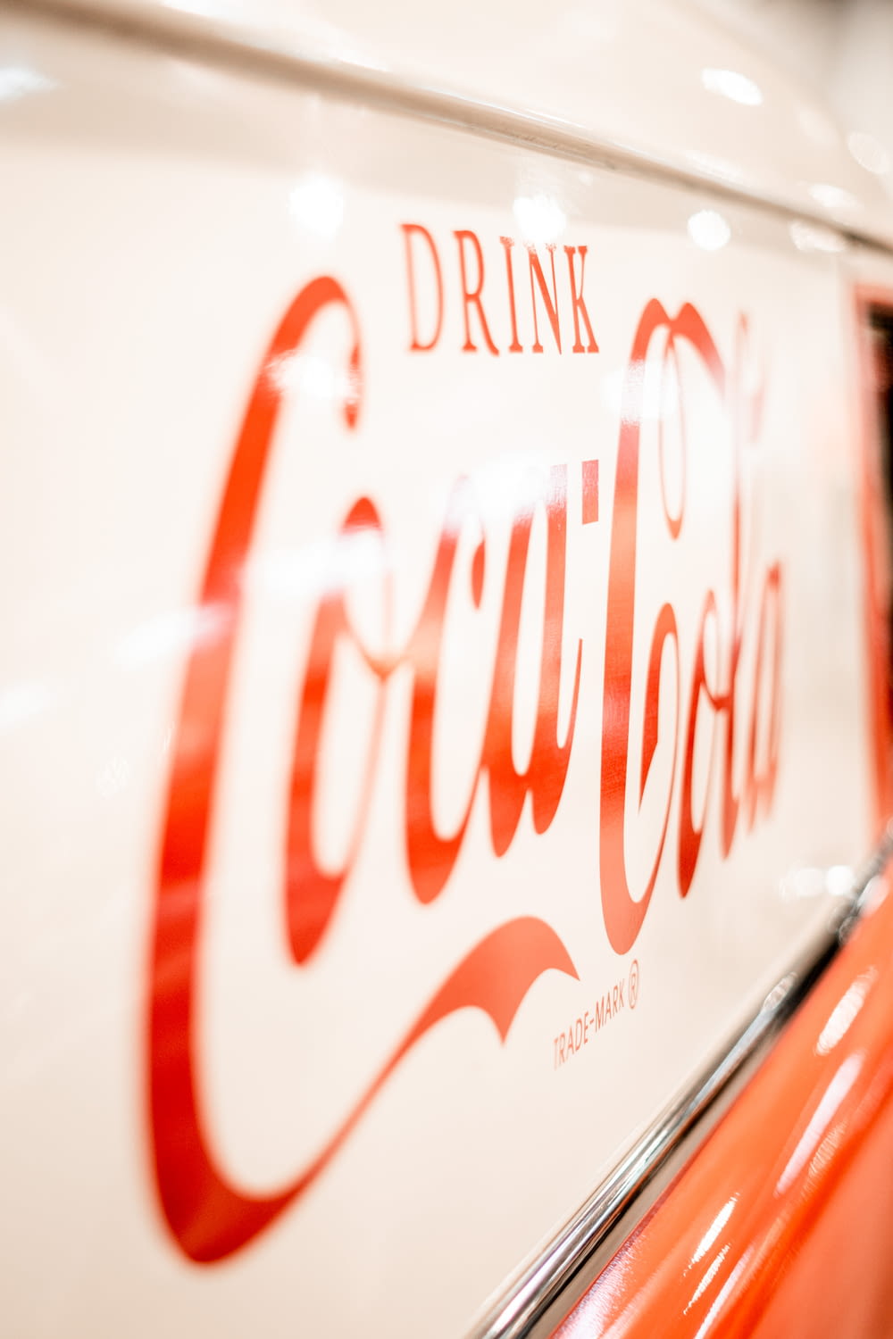 a close up of a coca cola sign on a car