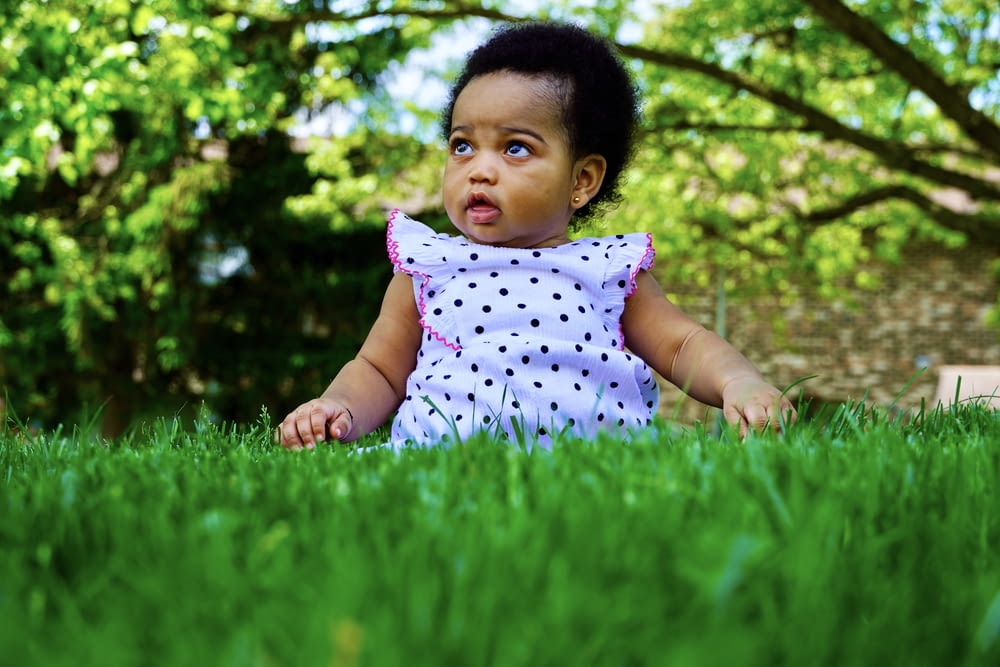 驚いた表情で草の中に座っている少女