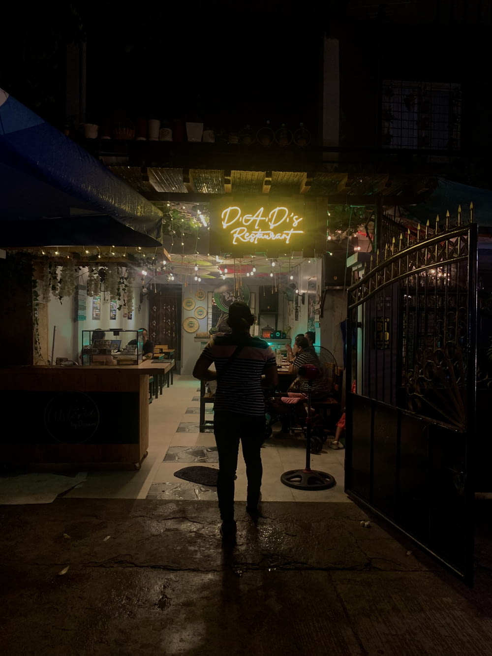 Una donna in piedi fuori di un ristorante di notte