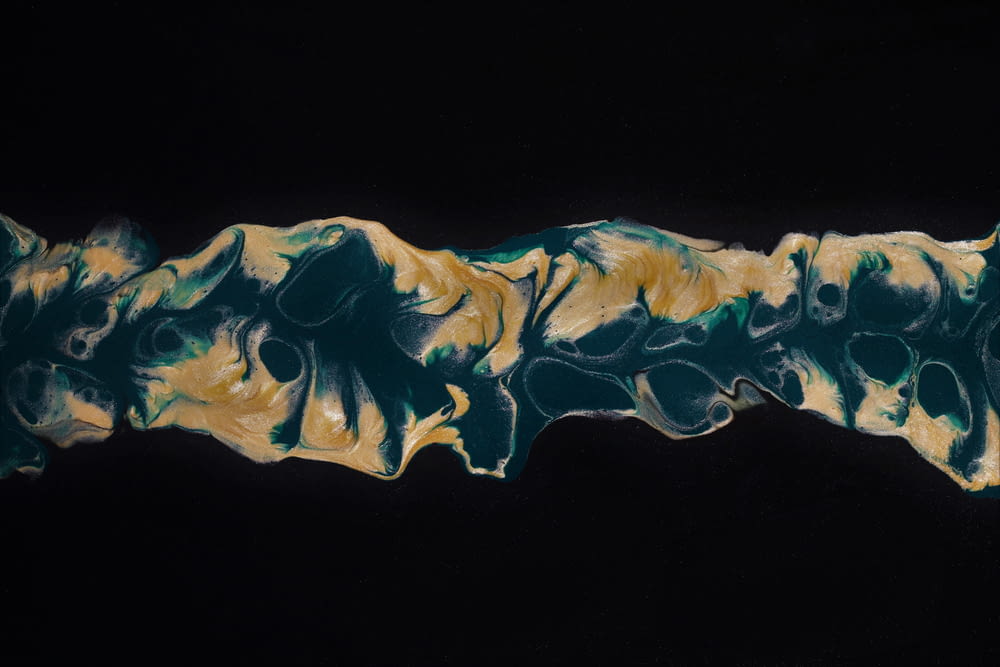 a painting of a black background with yellow and green swirls