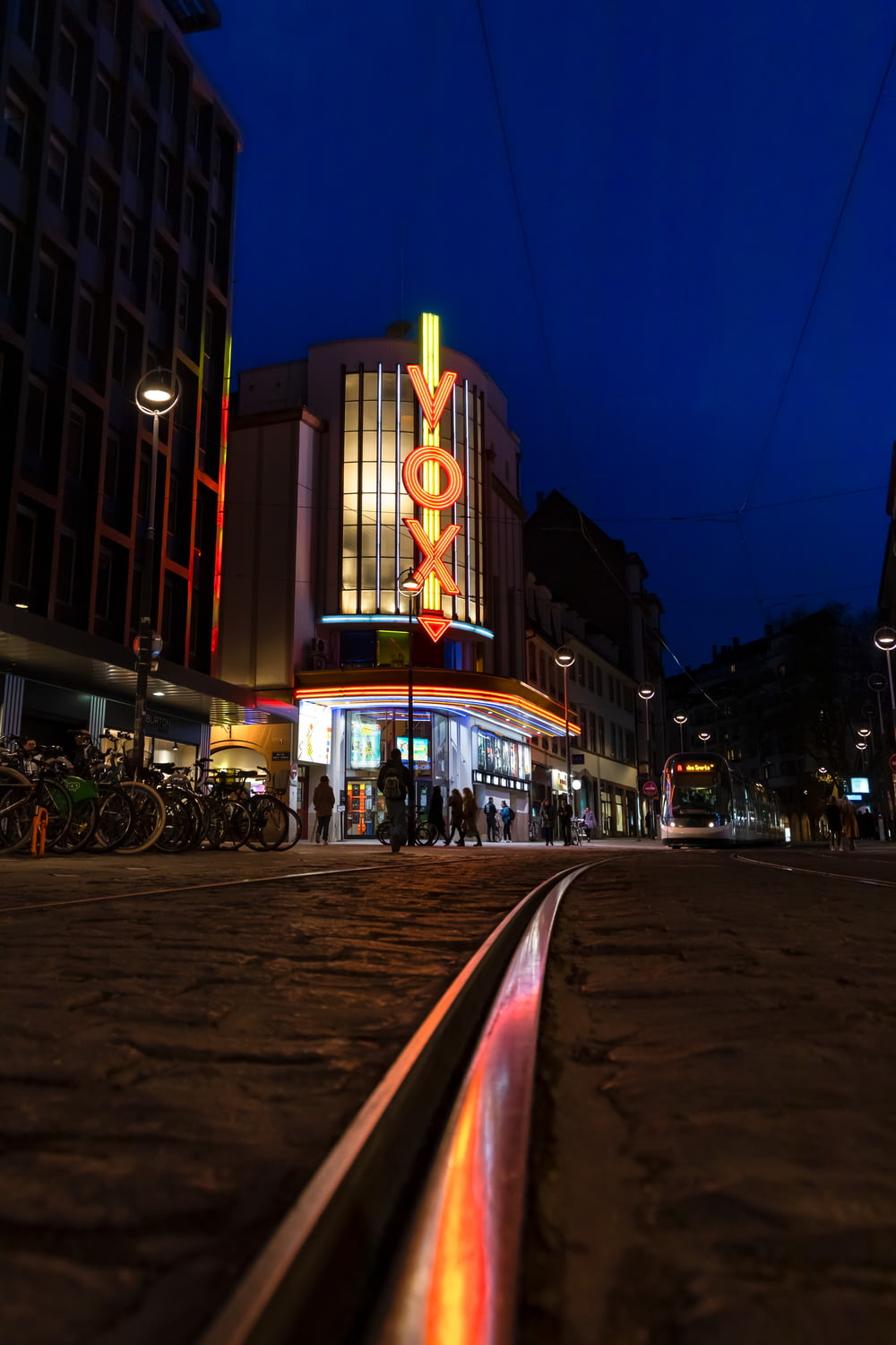 a train track in front of a building at night