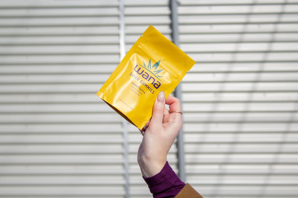 a person holding up a yellow bag of marijuana