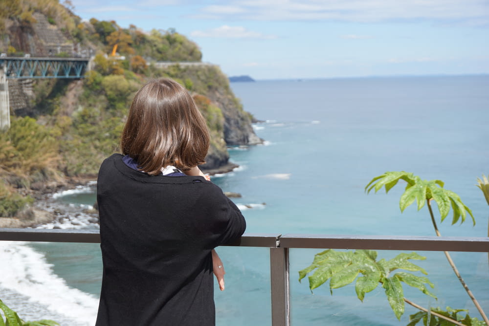 Una donna in piedi su un balcone che guarda l'oceano