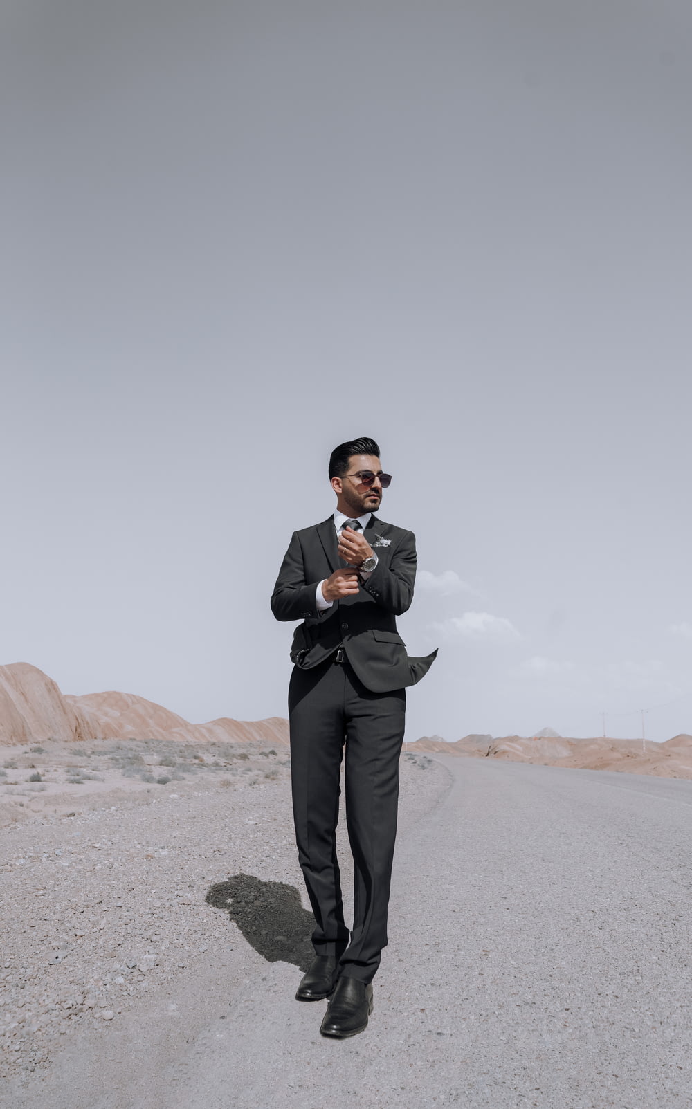 a man in a suit is standing in the middle of the road