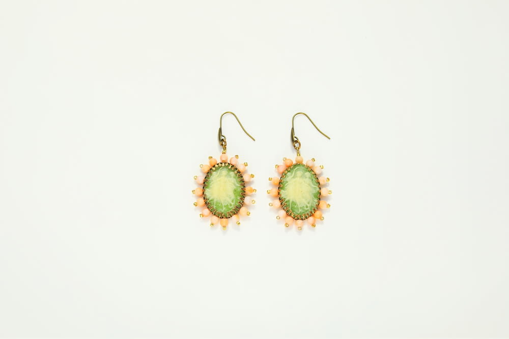 a pair of green and yellow earrings