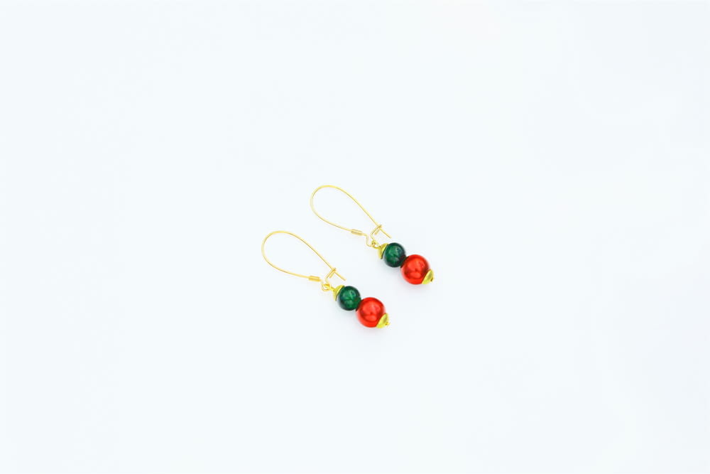 a pair of red, green and gold earrings