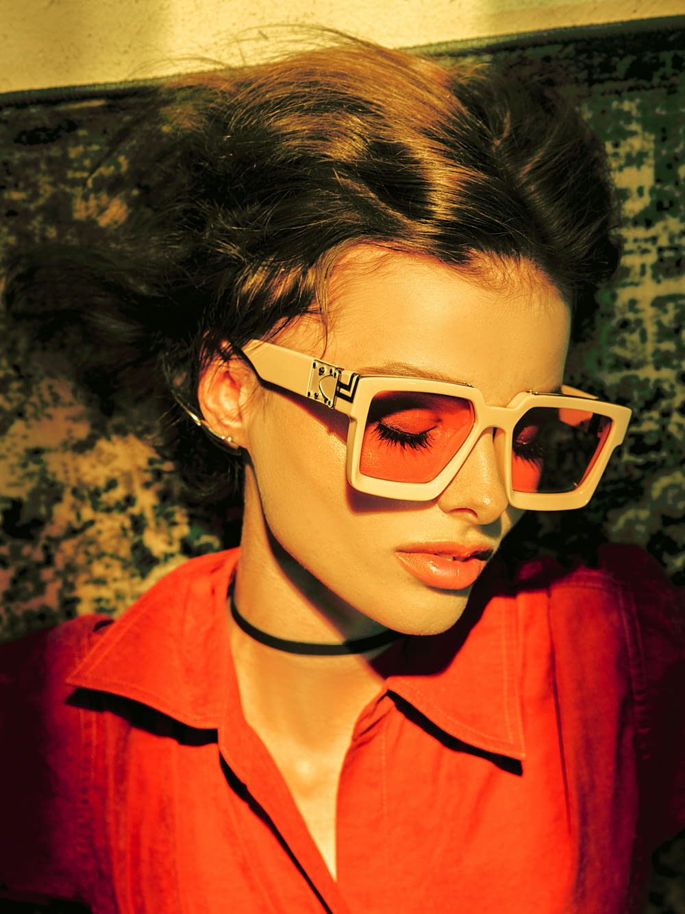 a woman in a red shirt and white sunglasses