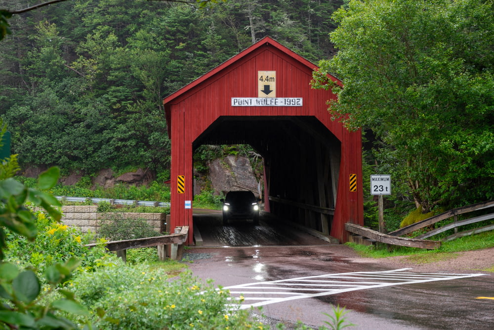 a red covered bridge over a wet road