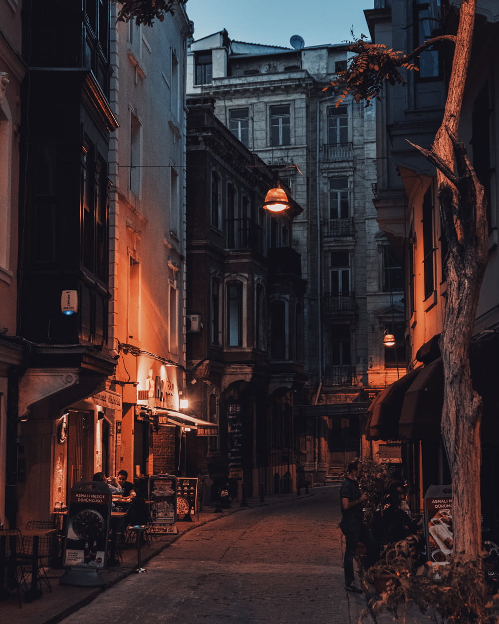 a narrow street with a lamp hanging over it