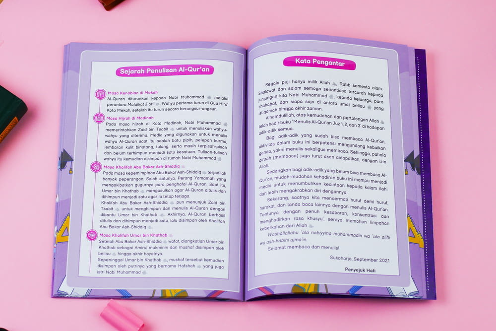 a book opened to a page on a pink surface