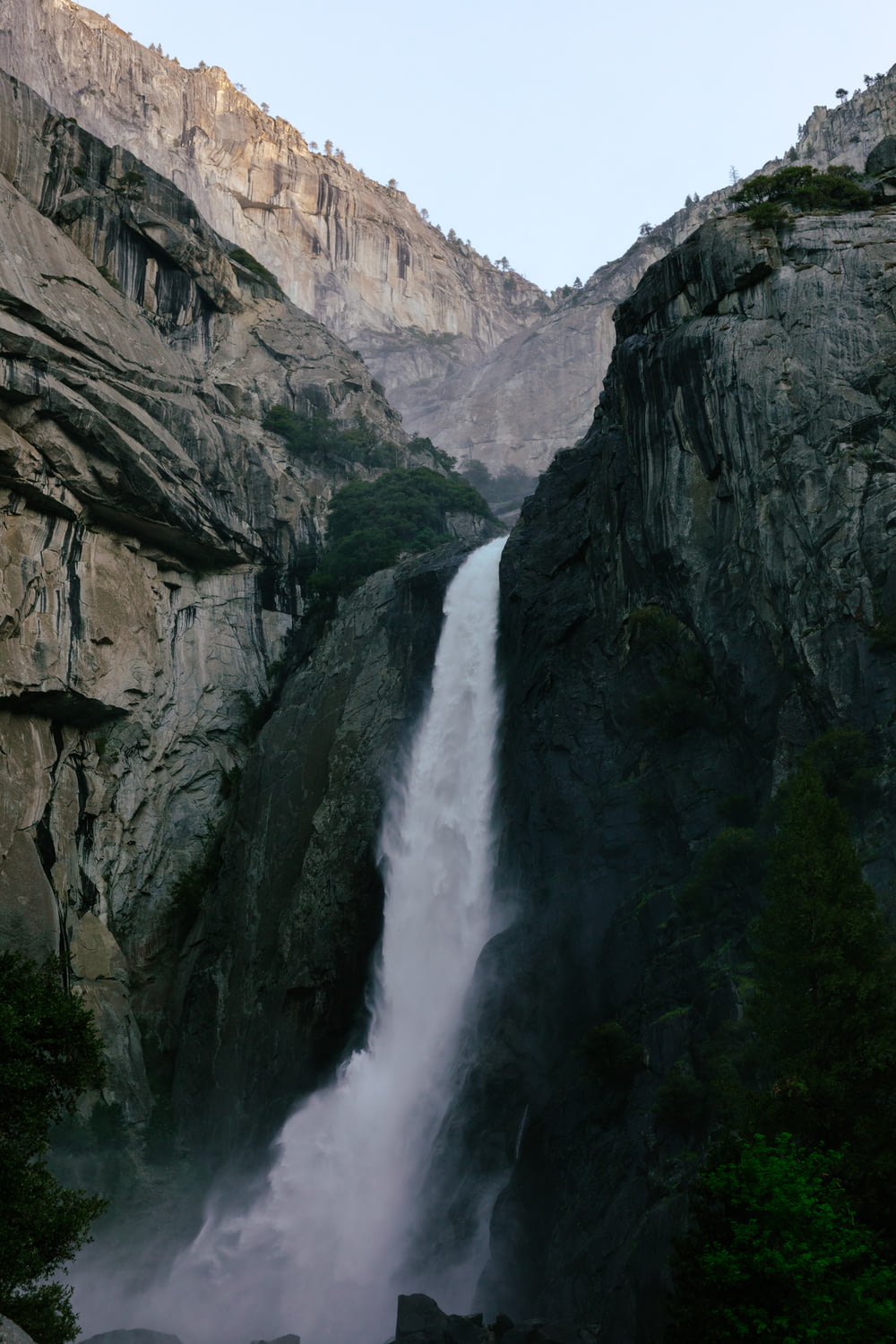 a very tall waterfall in the middle of a mountain