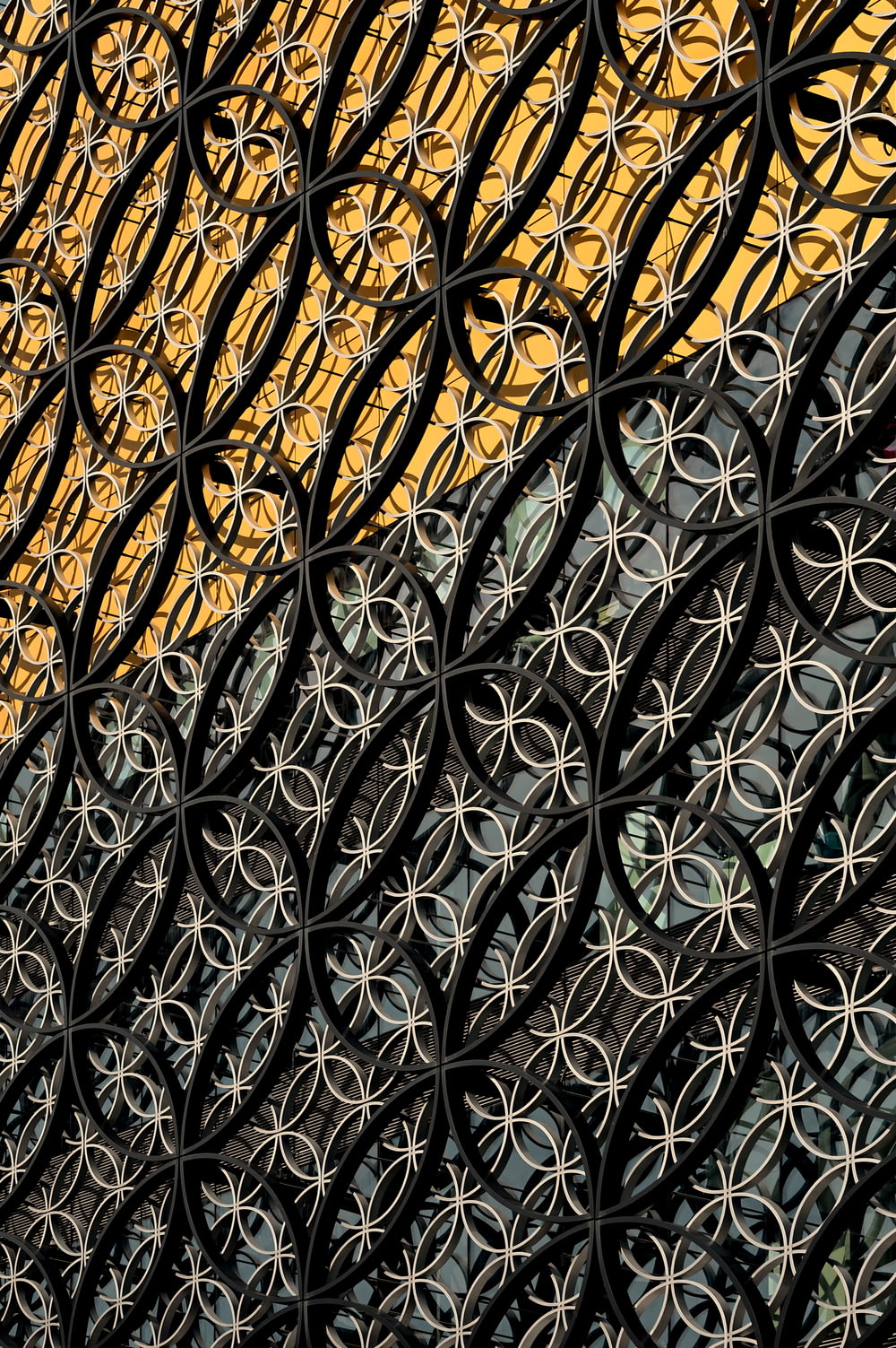 a close up of a metal fence with a building in the background