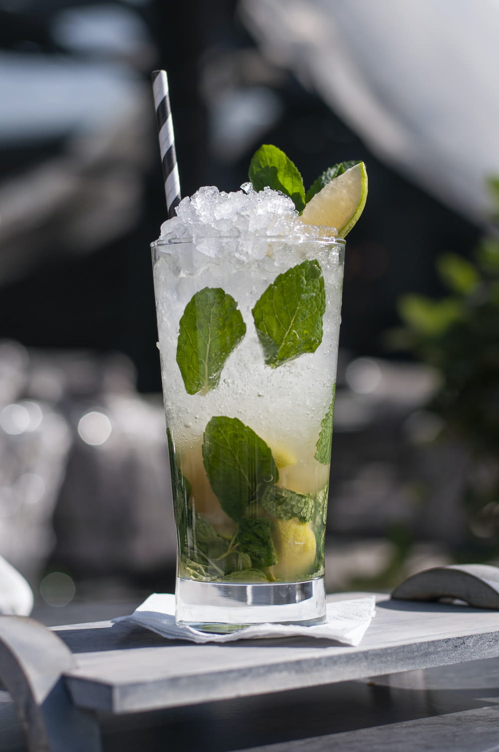 a glass of ice water with a lime and mint garnish