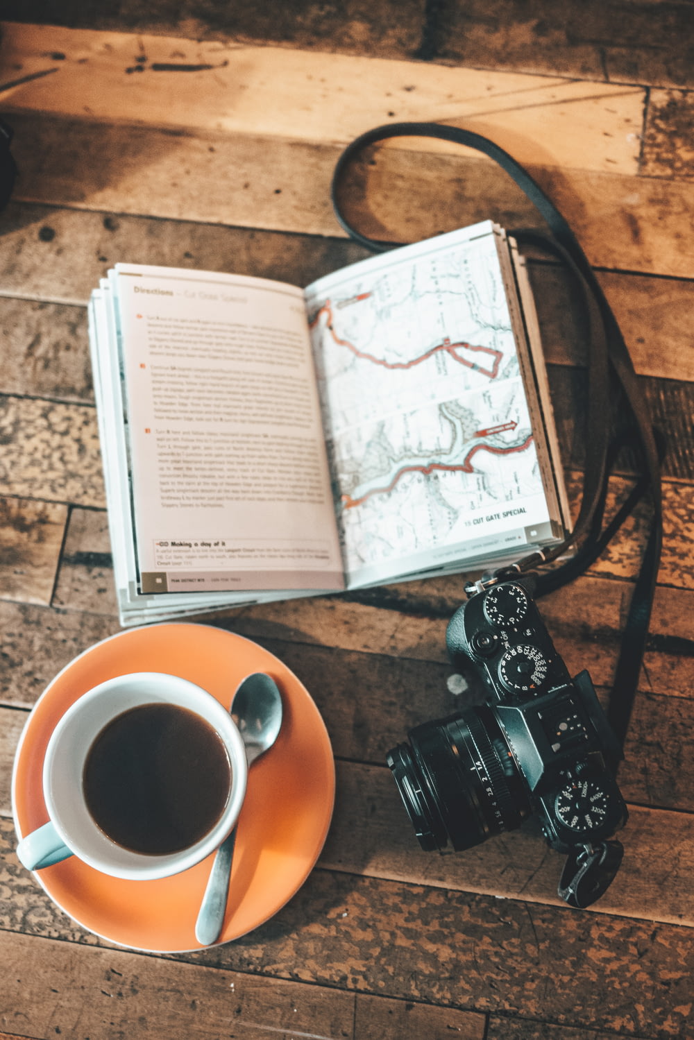 a camera, a book, and a cup of coffee on a table