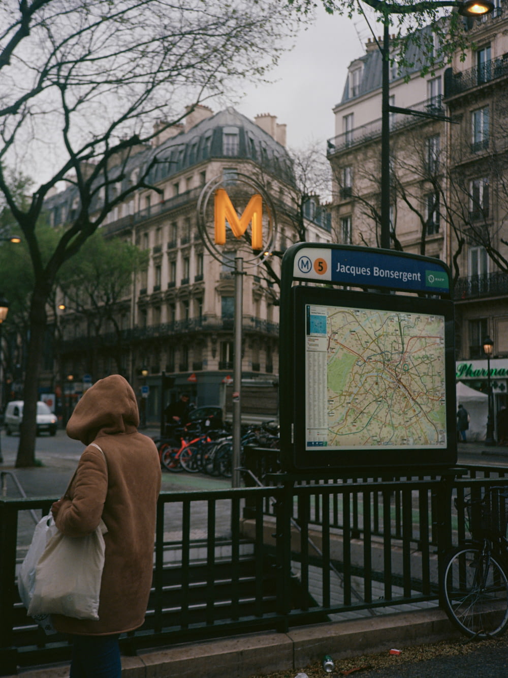 a person in a brown jacket is looking at a map