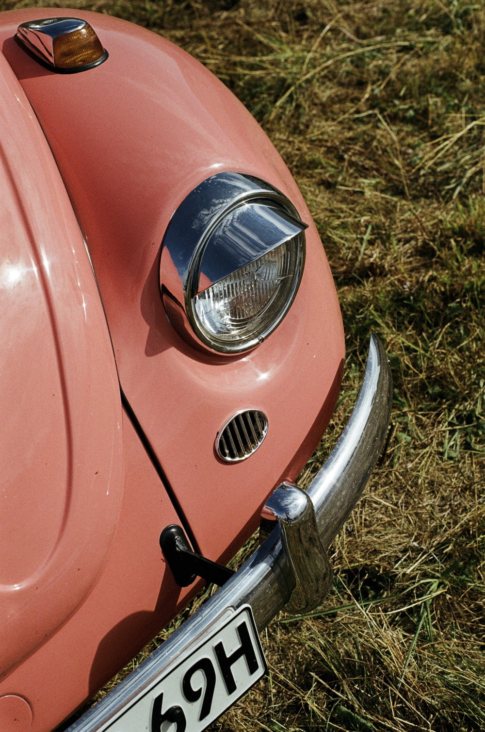 a close up of the front end of a pink car